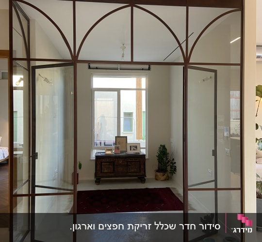 דלתות זכוכית עם מסגרת מתכת, שטיח אדום, שידה עם תמונות ועציץ